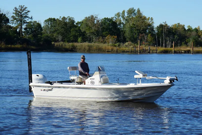 Slide: The Image of Bulls Bay 2000 boat from 2022 on a serene lake with lush greenery. - 7