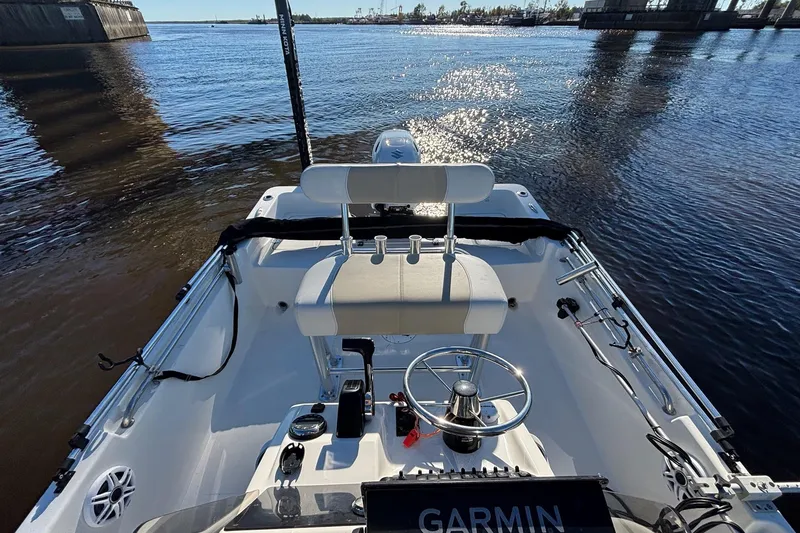 Slide: The Image of 2022 Bulls Bay 2000 boat interior with steering wheel and Garmin navigation on calm water. - 9
