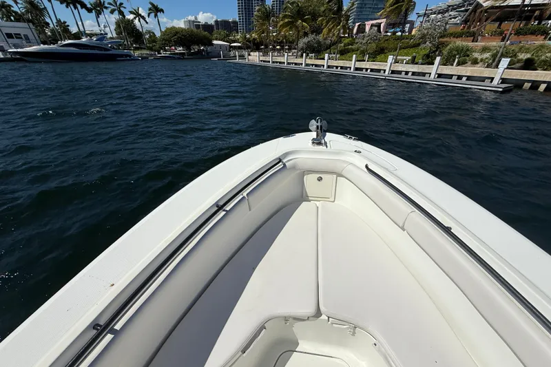 Slide: The Image of 2003 Hydra-Sports Vector 3300 CC boat on water near a dock, surrounded by palm trees. - 22