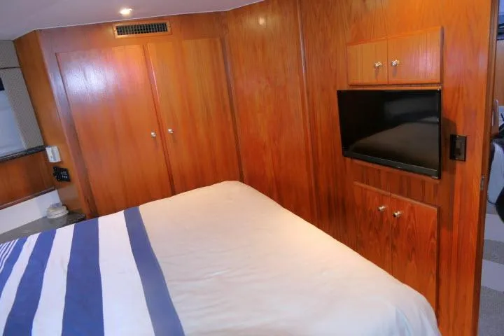 Slide: The Image of Interior of 2000 Carver 406 Motor Yacht with wood paneling and mounted TV. - 12