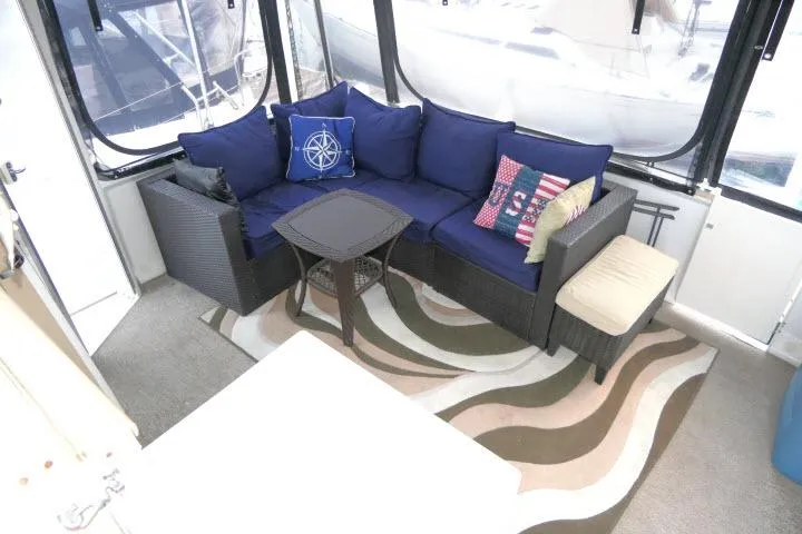 Slide: The Image of 2000 Carver 406 Motor Yacht interior with cozy seating and nautical-themed cushions. - 15