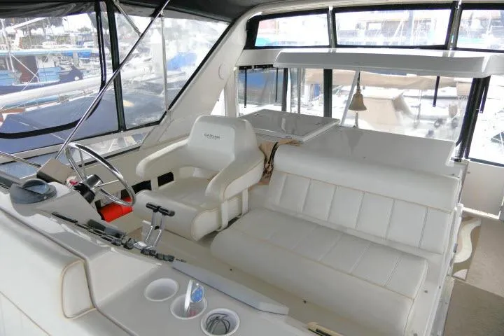 Slide: The Image of Interior of 2000 Carver 406 Motor Yacht with white seating and helm station. - 19