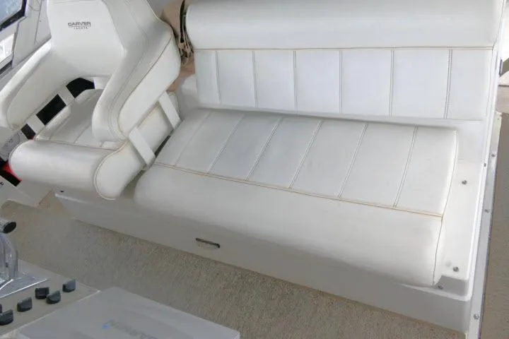 Slide: The Image of White leather seating on 2000 Carver 406 Motor Yacht, featuring helm chair and bench. - 20