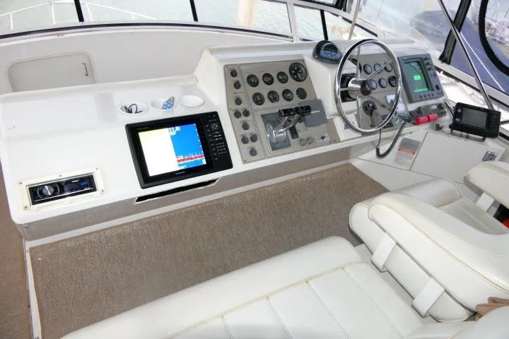 Slide: The Image of 2000 Carver 406 Motor Yacht helm with navigation instruments and steering wheel. - 22
