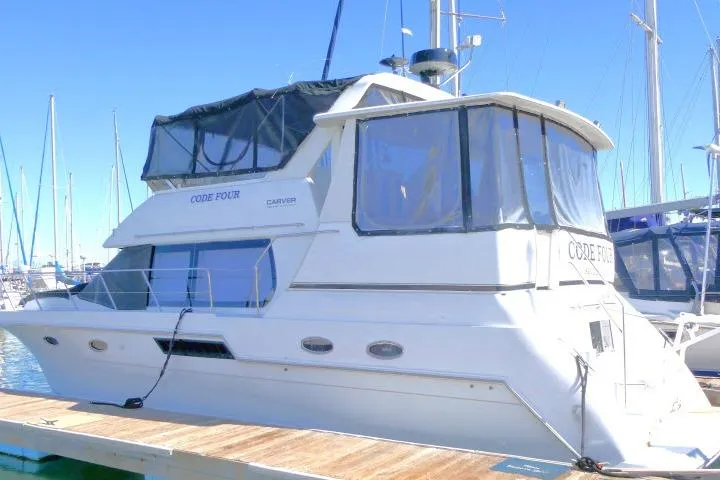Slide: The Image of 2000 Carver 406 Motor Yacht docked at marina under clear blue sky. - 34