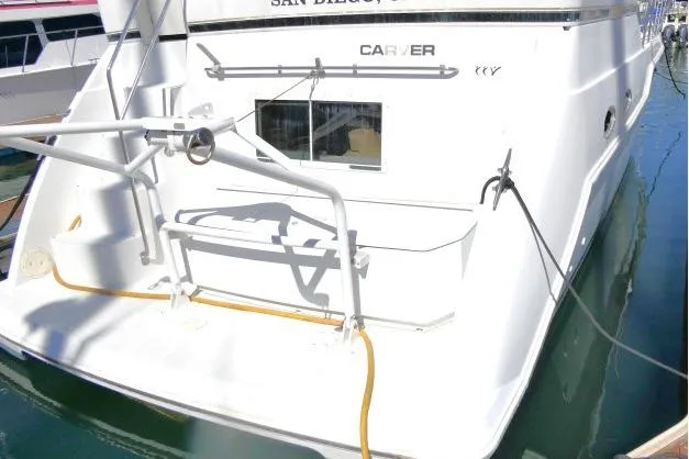 Slide: The Image of Carver 406 Motor Yacht 2000 docked, rear view with visible deck and railing. - 37