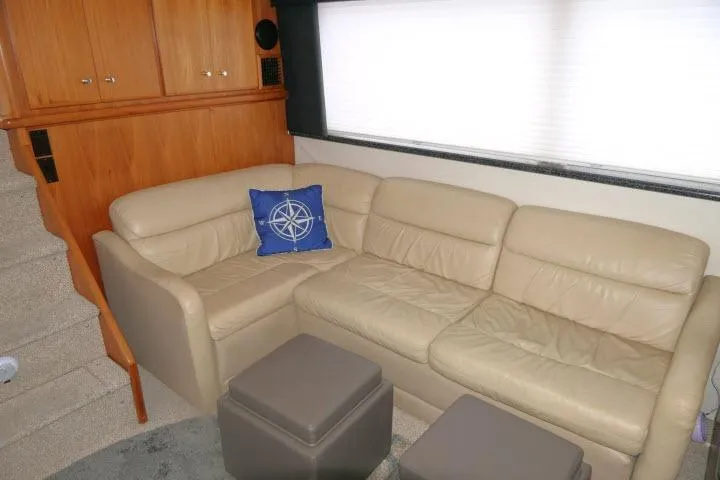 Slide: The Image of Interior of 2000 Carver 406 Motor Yacht with beige leather sofa and nautical-themed pillow. - 5