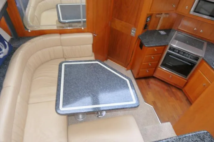 Slide: The Image of Interior of 2000 Carver 406 Motor Yacht with dining area and kitchen amenities. - 6