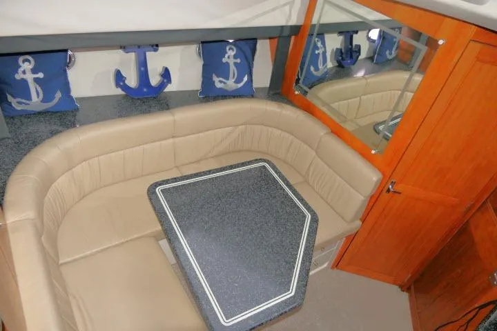 Slide: The Image of Interior of 2000 Carver 406 Motor Yacht with beige seating and nautical-themed decor. - 7