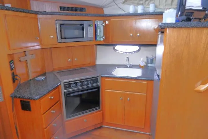 Slide: The Image of Kitchen area of 2000 Carver 406 Motor Yacht with wood cabinetry and modern appliances. - 8