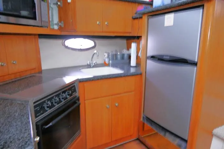 Slide: The Image of Kitchen area of 2000 Carver 406 Motor Yacht with stove, sink, and refrigerator. - 9