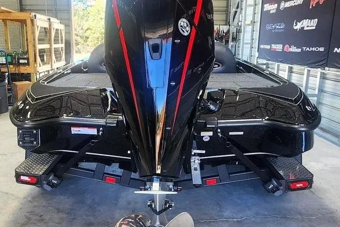 Slide: The Image of 2026 Triton 18 TrX boat in garage, rear view with motor and trailer. - 5