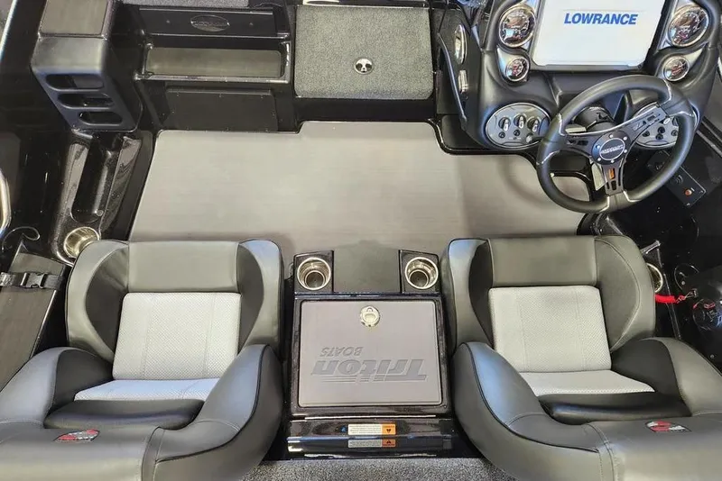 Slide: The Image of 2026 Triton 18 TrX boat interior with dual seats, steering wheel, and Lowrance electronics. - 7