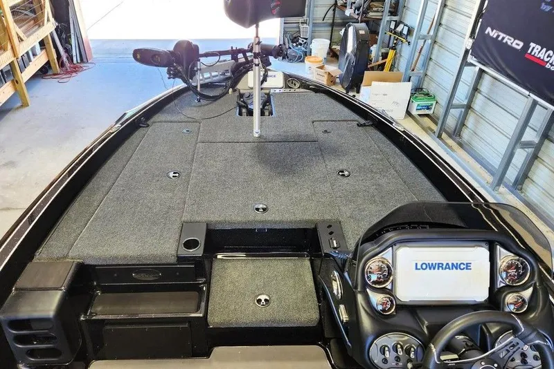 Slide: The Image of 2026 Triton 18 TrX boat interior with Lowrance electronics and spacious deck in a garage setting. - 9