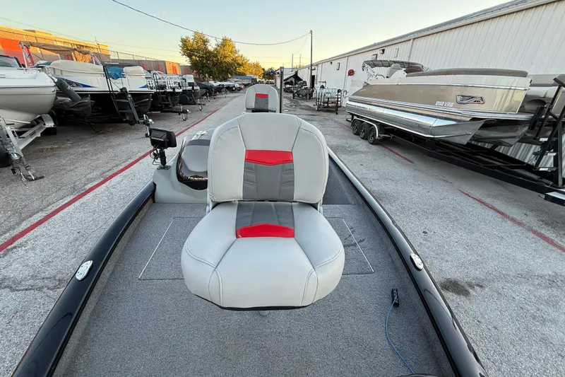 Slide: The Image of 2017 Tracker Pro Team 175 boat with gray and red seating, parked in a marina. - 23