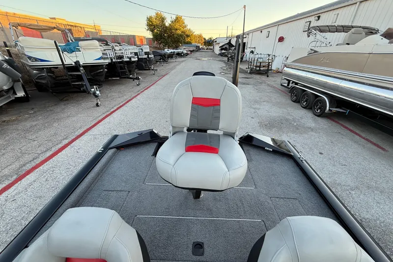 Slide: The Image of 2017 Tracker Pro Team 175 boat interior with seating, parked in a boatyard. - 33