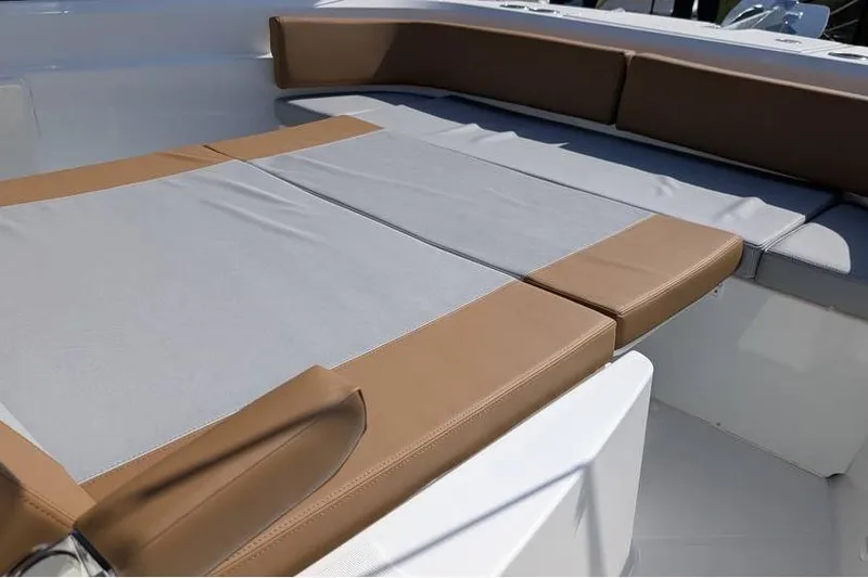 Slide: The Image of 2024 Beneteau Flyer 9 SPACEdeck boat seating area with tan and gray cushions. - 5