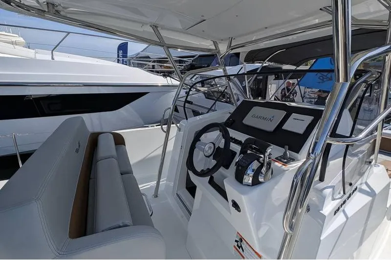 Slide: The Image of 2024 Beneteau Flyer 9 SPACEdeck boat interior with steering wheel and Garmin navigation system. - 6