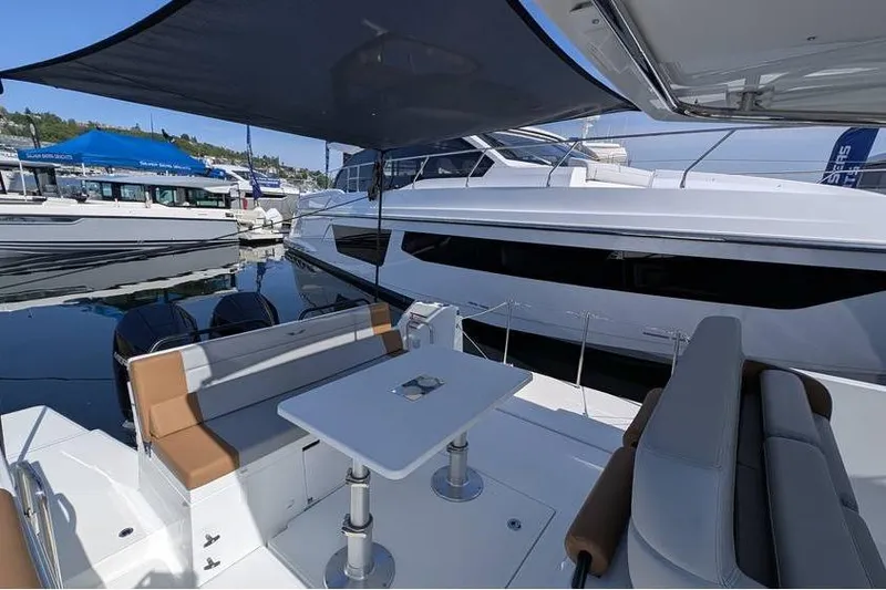 Slide: The Image of 2024 Beneteau Flyer 9 SPACEdeck with shaded seating area and table at marina. - 9