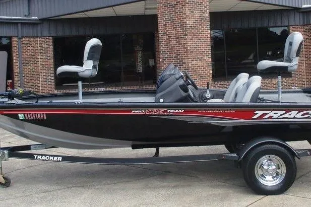 The Image of 2018 Tracker Pro Team 175 TXW fishing boat on trailer, parked outside a brick building. - 1