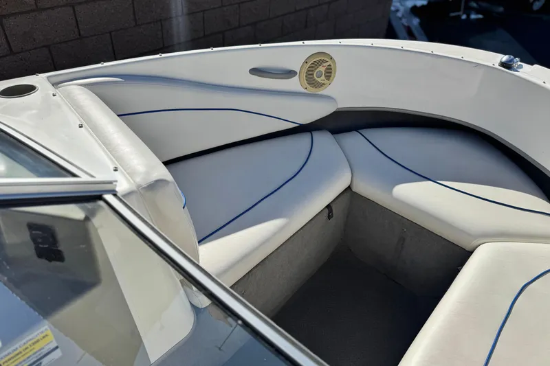 Slide: The Image of 2006 Bayliner 215 Bowrider interior with white cushioned seating and blue accents. - 10