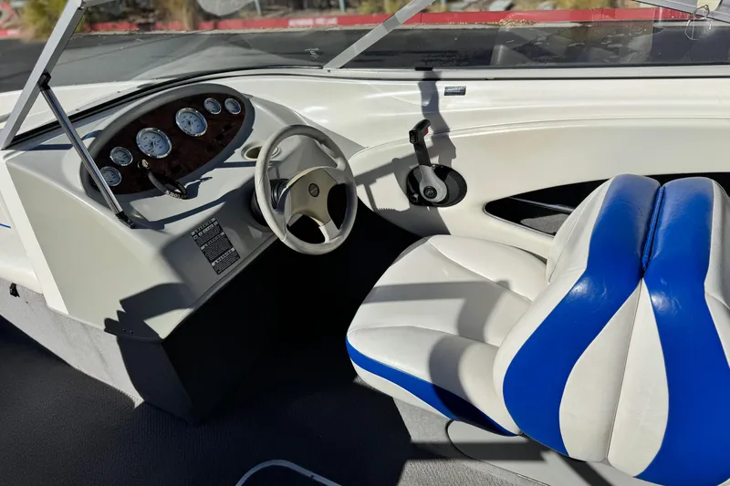 Slide: The Image of 2006 Bayliner 215 Bowrider cockpit with steering wheel and blue-white seating. - 22