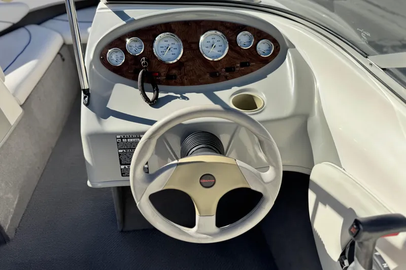Slide: The Image of 2006 Bayliner 215 Bowrider dashboard with steering wheel and gauges. - 23