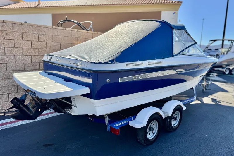 Slide: The Image of 2006 Bayliner 215 Bowrider boat on trailer, covered and parked outdoors. - 6