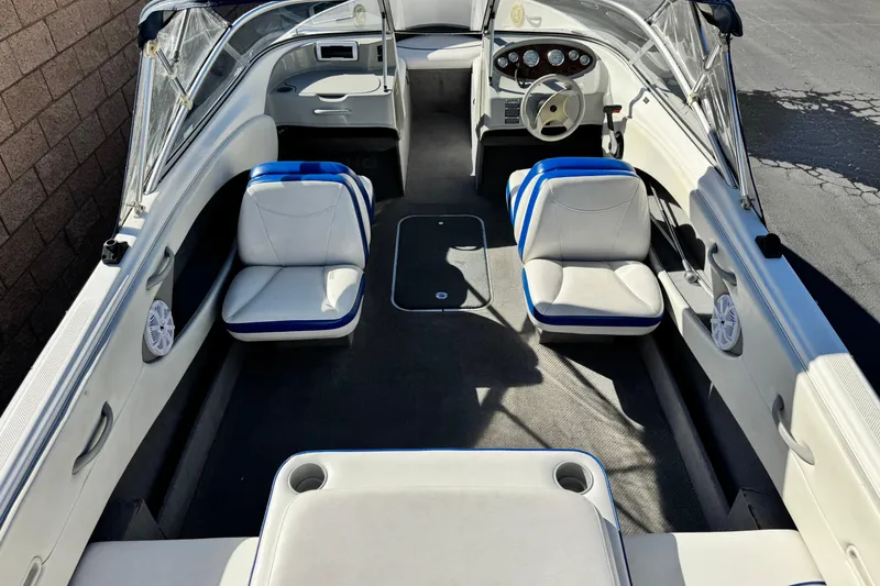 Slide: The Image of 2006 Bayliner 215 Bowrider interior with white and blue seating, steering console, and open layout. - 8