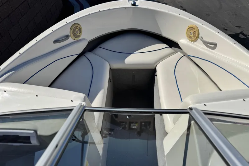 Slide: The Image of 2006 Bayliner 215 Bowrider interior with white seating and speakers. - 9