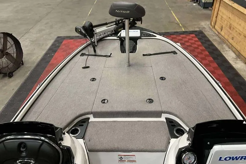 Slide: The Image of 2016 Nitro Z18 boat interior with gray carpet and fishing equipment. - 9