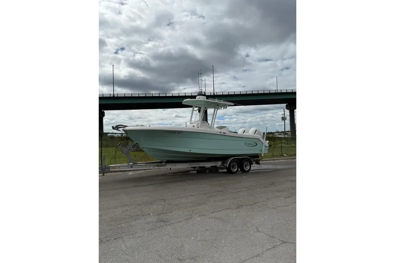 Slide: The Image of 2022 Robalo R242 Center Console boat on trailer under cloudy sky. - 10