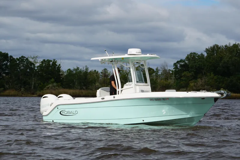Slide: The Image of 2022 Robalo R242 Center Console boat on water, with trees in the background. - 3