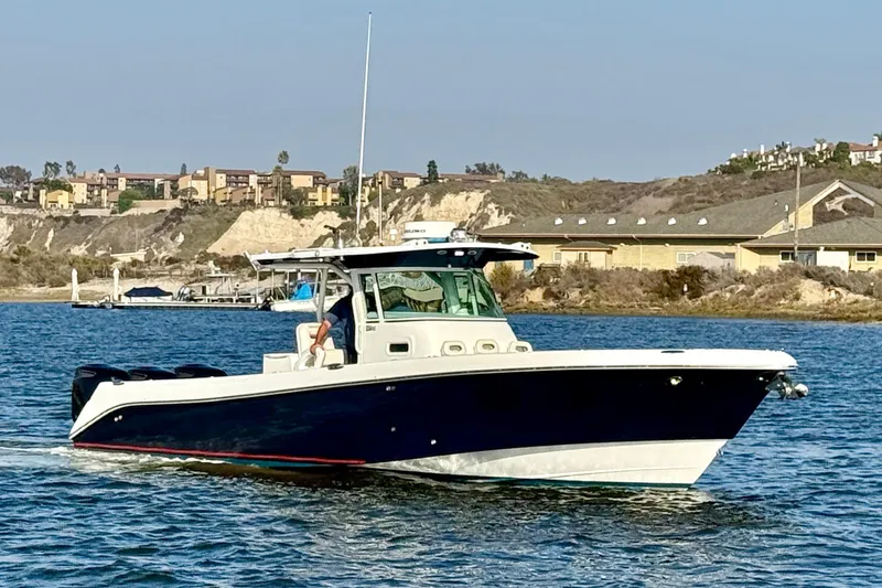 Slide: The Image of 2008 Everglades 350 Center Console boat cruising on a sunny day near coastal buildings. - 1