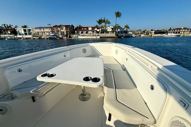 Slide: The Image of 2008 Everglades 350 Center Console boat interior with seating and table, docked near waterfront homes. - 19
