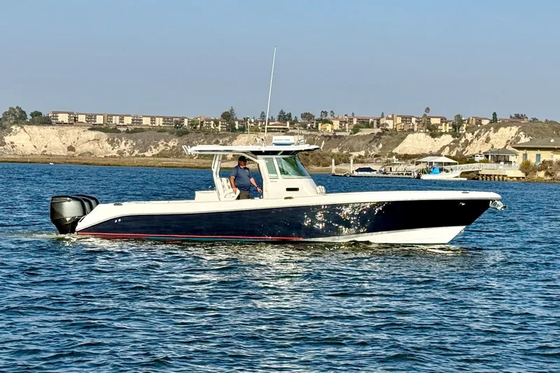 Slide: The Image of 2008 Everglades 350 Center Console boat cruising on a sunny day near coastal buildings. - 2