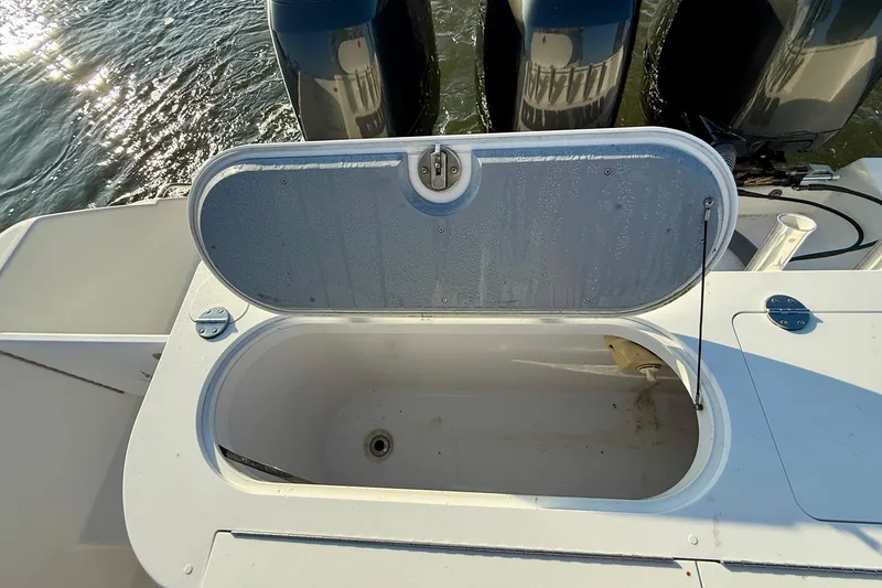 Slide: The Image of Open storage compartment on 2008 Everglades 350 Center Console boat, with visible engines in background. - 39