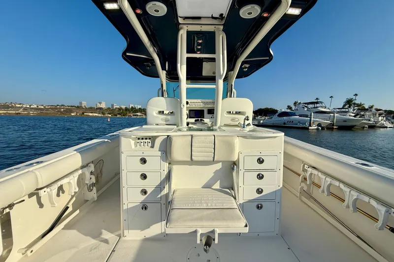 Slide: The Image of 2008 Everglades 350 Center Console boat interior with seating and storage, docked by the water. - 44