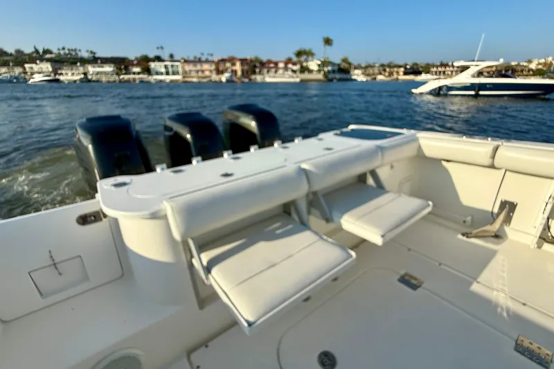 Slide: The Image of 2008 Everglades 350 Center Console boat with triple engines, docked near waterfront homes. - 49