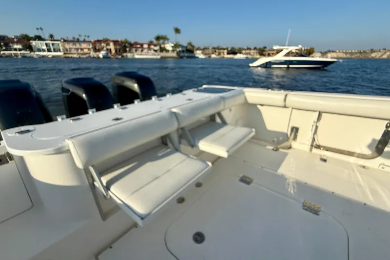 Slide: The Image of 2008 Everglades 350 Center Console boat interior with seating, ocean view, and nearby yacht. - 50