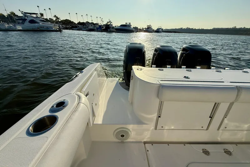 Slide: The Image of 2008 Everglades 350 Center Console boat with triple engines docked in a marina. - 53