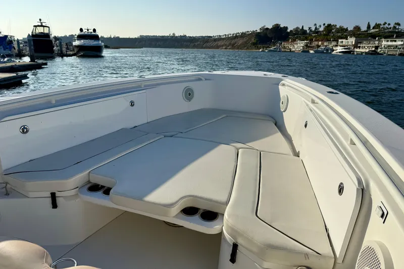 Slide: The Image of 2008 Everglades 350 Center Console boat interior with cushioned seating, docked by the water. - 8