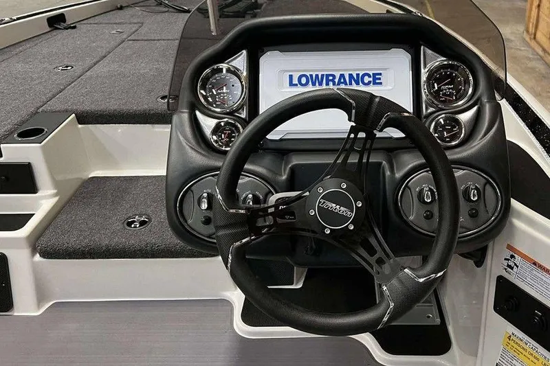Slide: The Image of 2026 Triton 18 TrX boat dashboard with Lowrance display and steering wheel. - 3