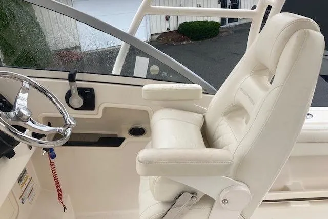 Slide: The Image of 2020 Grady-White Freedom 235 boat interior with captain's chair and steering wheel. - 12