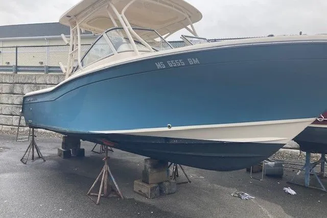 Slide: The Image of 2020 Grady-White Freedom 235 boat on stands, blue hull, outdoor storage. - 3