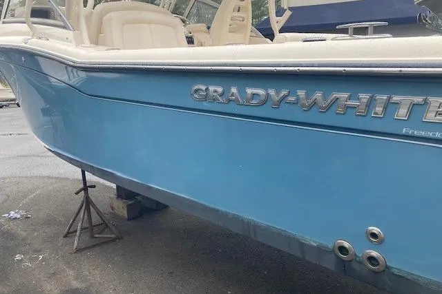 Slide: The Image of 2020 Grady-White Freedom 235 boat in blue, docked on stands. - 7