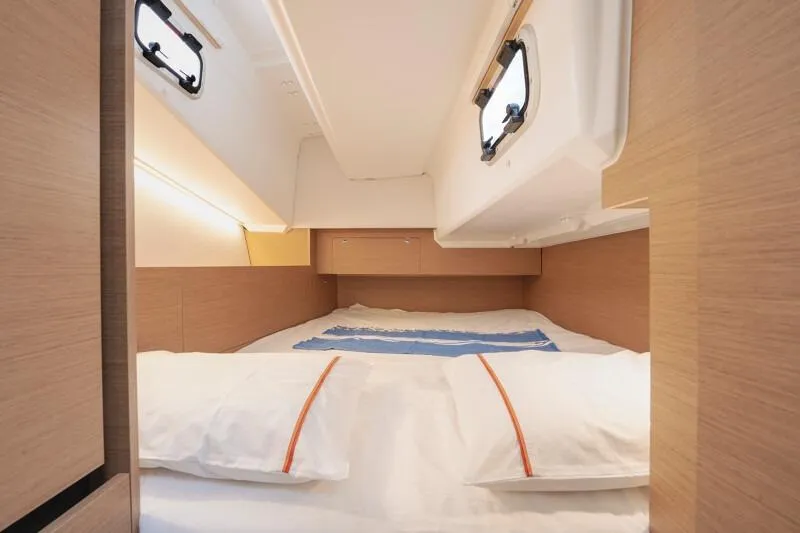 Slide: The Image of Cozy cabin interior of 2026 Jeanneau Sun Odyssey 350 sailboat, featuring a comfortable bed. - 11