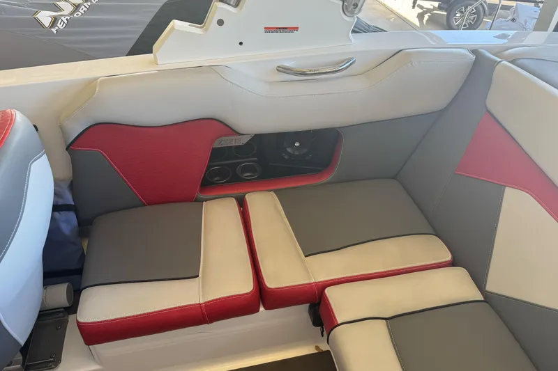 Slide: The Image of 2023 Supreme ZS212 boat interior with red and gray seating, docked at a marina. - 12