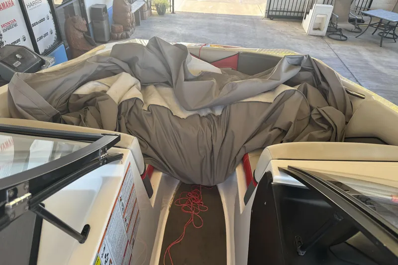 Slide: The Image of 2023 Supreme ZS212 boat interior with red and gray seating, cup holders, and speakers. - 24