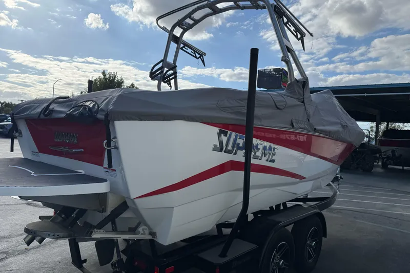 Slide: The Image of 2023 Supreme ZS212 boat, rear view, covered, parked outdoors. - 3